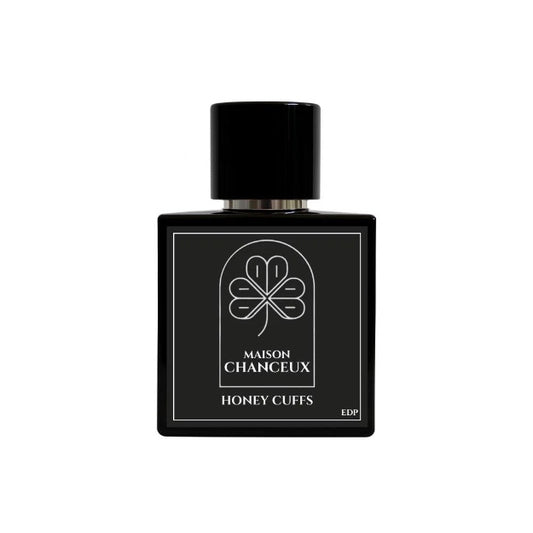 Black perfume bottle labeled 'Maison Chanceux Honey Cuffs' on a white background